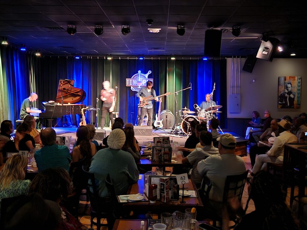 The Yellowjackets performing live on stage at The Tin Pan music venue in front of a full audience.
